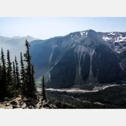 It Rainier Photography Art Print | Vista Of To Rainier Cliffs With Snow Behind Thick Forest Tree Line And River Far Below